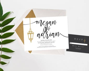 May include: A white wedding invitation with black calligraphy text that reads "Megan & Adrian" with a gold lantern graphic. The invitation includes the date, time, and location of the wedding. A black RSVP card with a gold lantern graphic is also included.