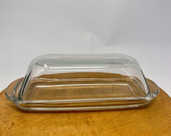 Mantequera de vidrio transparente vintage, con una pequeña imperfección.