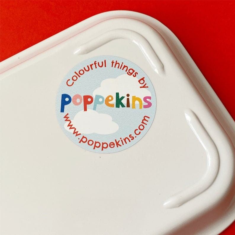 K&ouml;nnte beinhalten: Ein wei&szlig;er runder Aufkleber mit blauem Hintergrund und wei&szlig;en Wolken. Der Aufkleber sagt "Colourful things by Poppekins www.poppekins.com" in bunten Buchstaben.
