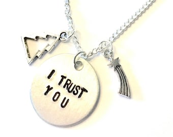 May include: A silver necklace with a round charm that says "I Trust You". The necklace also has a small tree charm and a shooting star charm.