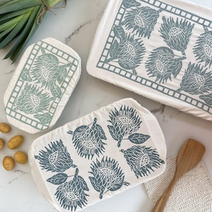May include: A set of three ceramic mugs with a speckled, matte finish in cream, light grey, and dark grey. Each mug has a simple, minimalist design and a rounded handle.