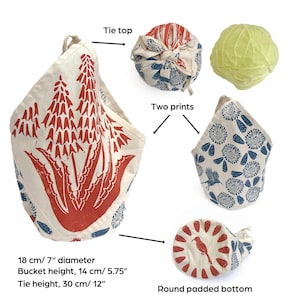 May include: A reusable fabric produce bag with a round padded bottom, a tie top, and two different prints. The bag is 7 inches in diameter, 5.75 inches tall, and the tie is 12 inches long. The bag is shown with a cabbage inside.