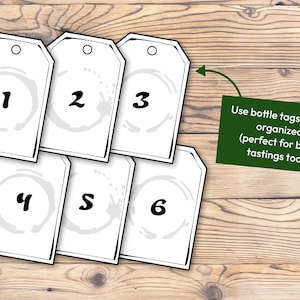May include: Six white bottle tags with black numbers 1 to 6 and a grey stain design. A green sign with white text reads "Use bottle tags to stay organised (perfect for blind tastings too!)".