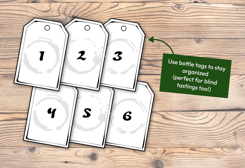 May include: Six white bottle tags with black numbers 1 to 6 and a grey stain design. A green sign with white text reads "Use bottle tags to stay organised (perfect for blind tastings too!)".
