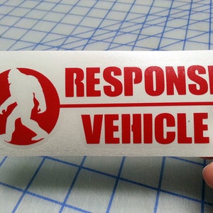 May include: White vinyl sticker with a red circle containing a white silhouette of Bigfoot. The text "RESPONSE VEHICLE" is in red letters.