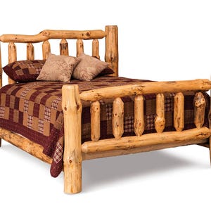 May include: A rustic bed frame constructed from thick, light-colored natural logs with a prominent headboard and footboard. The bed is dressed with a dark brown and tan checkered quilt and two matching square pillows with a subtle patterned design.