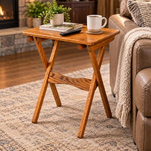 May include: A rectangular wooden folding snack table with a medium brown finish and an X-frame base. The table features a smooth top surface with a horizontal support brace connecting the legs, providing a stable structure for living room use.