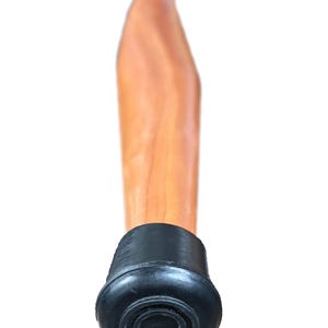 May include: A wooden walking cane with a light brown finish. The cane has a curved handle and a black rubber tip for stability. The cane is designed for support and mobility.
