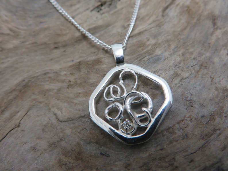 sterling silver pendant set with a diamond on white gold claws