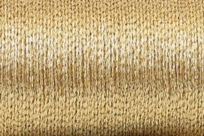 May include: A spool of gold and white metallic thread. The thread is wound tightly around the spool and has a shiny, metallic finish.