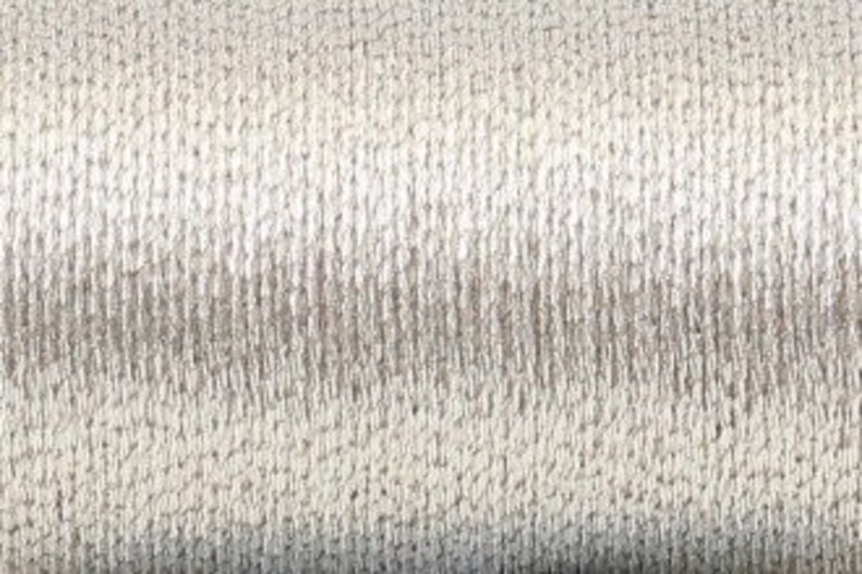 May include: A spool of silver metallic embroidery thread.