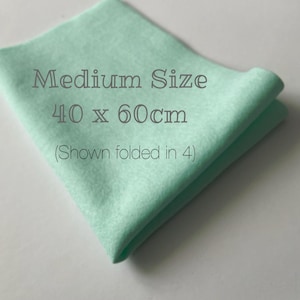 May include: A folded, medium-sized, light green fabric square, measuring 40 x 60 cm. The text on the fabric reads "Medium Size" and "40 x 60cm (Shown folded in 4)". The fabric is folded in four.