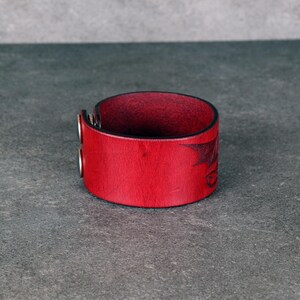 Handmade leather bracelet with dragon engraving.