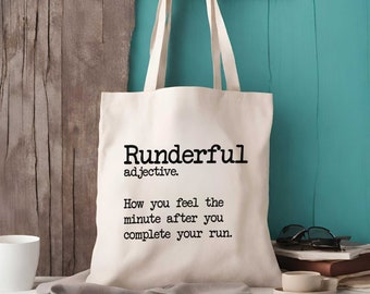 Puede incluir: Una bolsa de tela de color crema con dos correas para el hombro. La parte frontal presenta un texto impreso en negro que dice: Runderful adjective. How you feel the minute after you complete your run. La bolsa tiene una forma rectangular.