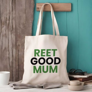 Puede incluir: Una bolsa de tela blanca con texto negro y verde que dice "REET GOOD MUM".