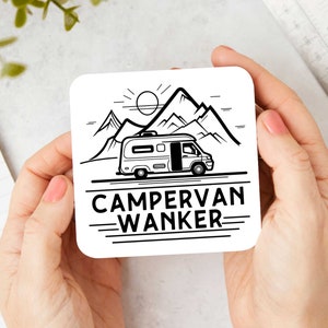 Könnte beinhalten: Ein quadratischer weißer Untersetzer mit einer schwarzen Strichzeichnung eines Wohnmobils vor Berggipfeln und einer Sonne. Der Text CAMPERVAN WANKER ist in fetten schwarzen Großbuchstaben unter der Fahrzeugabbildung aufgedruckt.