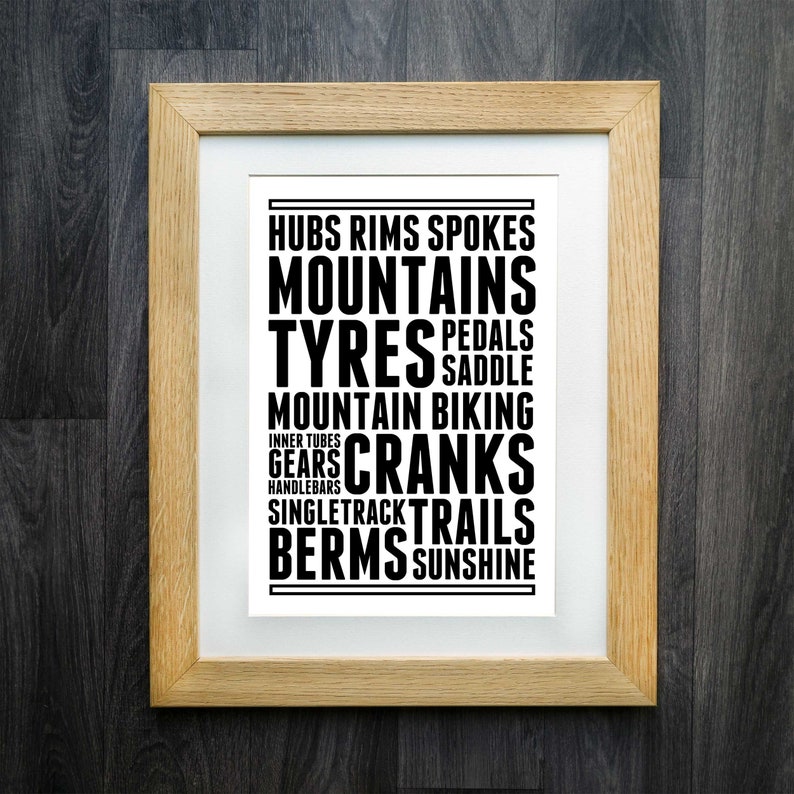 May include: A framed print with black text on a white background. The text reads "Hubs Rims Spokes Mountains Tyres Pedals Saddle Mountain Biking Inner Tubes Gears Cranks SingleTrack Trails Berms Sunshine".