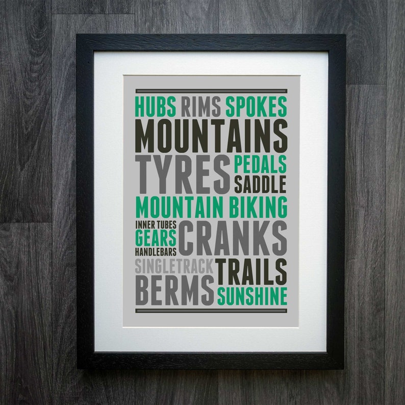 May include: A framed print with a gray background and black text. The text is arranged in a word cloud and includes the words "Hubs, Rims, Spokes, Mountains, Tyres, Pedals, Saddle, Mountain Biking, Inner Tubes, Gears, Cranks, Handlebar, Singletrack, Trails, Berms, Sunshine".