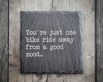 May include: A black slate sign with white text that reads "You're just one bike ride away from a good mood..."