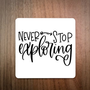 Può includere: Sottobicchiere quadrato bianco con calligrafia nera che recita "Never Stop Exploring" con una freccia che punta a destra.