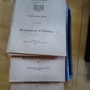 May include: Three vintage books titled "Development of Moldings", "Materials of Construction", and "Practical Projection" published by International Textbook Company in Scranton, PA.