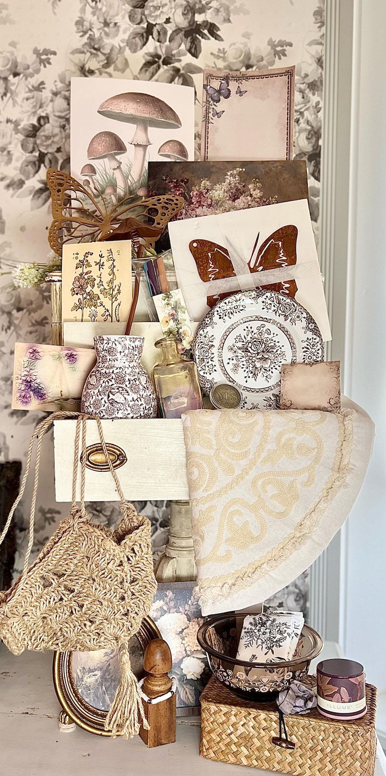 May include: An assortment of vintage-style items, including a woven bag, decorative plates, cards with butterfly and floral designs, a small vase, and a decorative butterfly. The color palette includes beige, brown, and white.