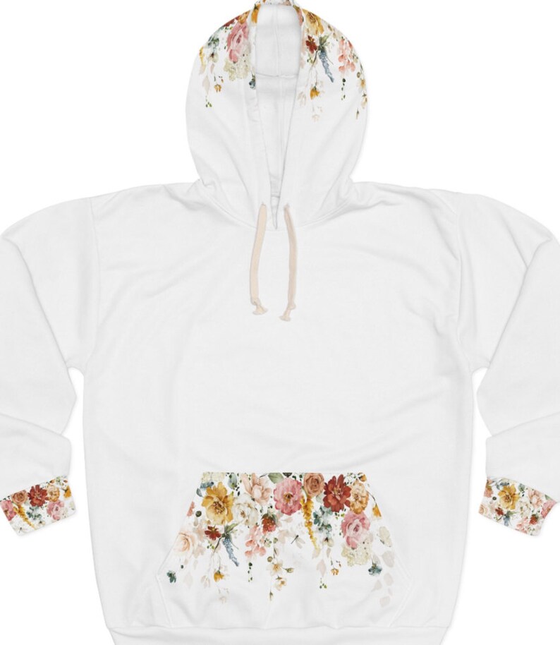 Op de afbeelding: Witte hoodie met een bloemenprint op de capuchon, manchetten en zak. De print bevat een verscheidenheid aan bloemen in tinten roze, geel en oranje.