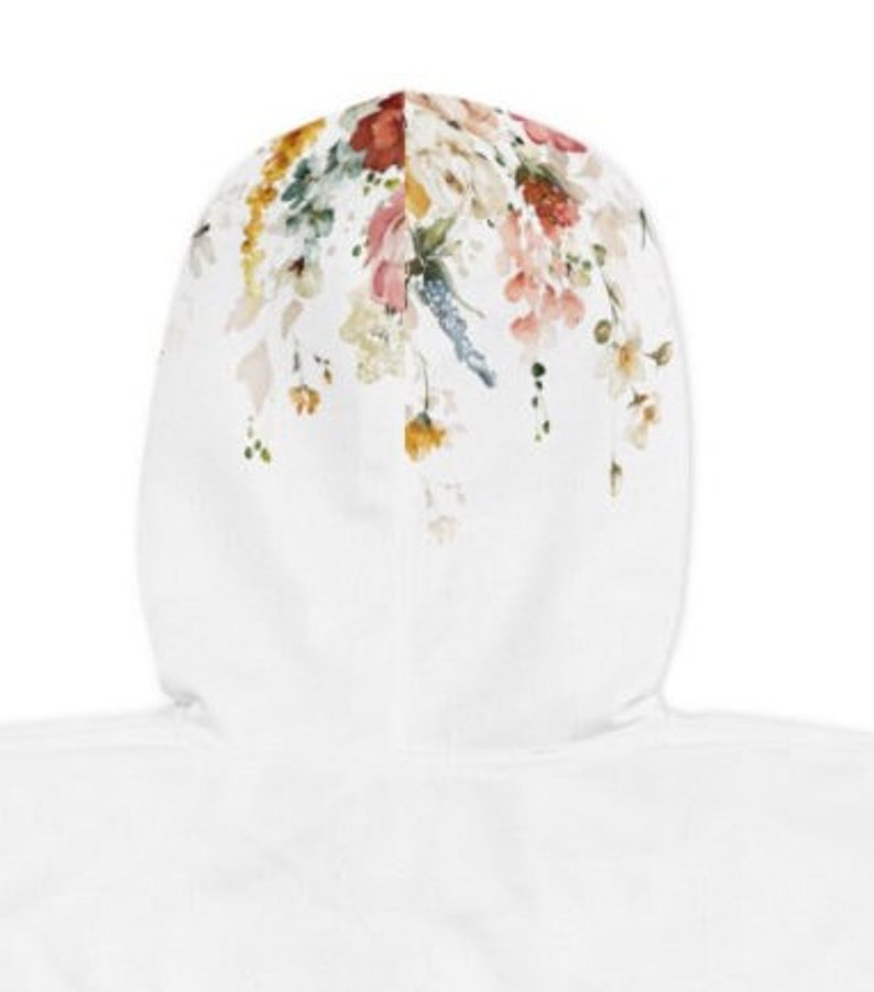 Op de afbeelding: Witte hoodie met een bloemenprint op de capuchon. De print bevat verschillende bloemen in tinten roze, rood, geel en blauw.