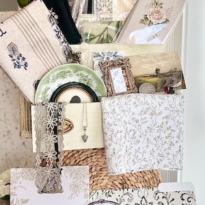 May include: A collection of vintage-style home decor items, including floral prints, a decorative plate, a necklace, and a sign that says "Bathroom". The color palette includes white, beige, green, and gold accents, creating a romantic and elegant aesthetic.