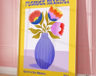 May include: A yellow poster with the text "FLOWER MARKET" in a retro font. The poster features a blue vase with three stylized flowers in shades of pink, red, orange, and yellow. The text "Galerie d'Art Moderne" and "No:1" are at the bottom of the poster.