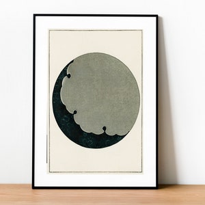 Puede incluir: Una impresión enmarcada de un diseño abstracto en negro y gris. El diseño presenta un círculo con una forma gris en su interior, que se asemeja a una nube o una luna creciente.