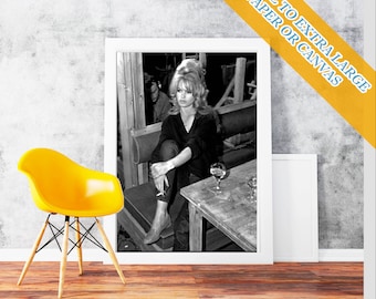 May include: A framed black and white photograph of a woman seated at a table, with a glass of wine. A yellow chair with wooden legs is in the foreground. The text "SMALL TO EXTRA LARGE PAPER OR CANVAS" is in the upper right corner.