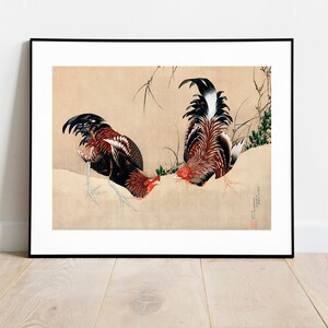Puede incluir: Una pintura japonesa vintage que representa dos gallos enfrentados. Los gallos están pintados en tonos rojos, negros y blancos sobre un fondo beige. La pintura está enmarcada en negro.