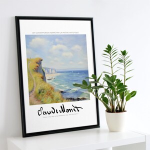 Puede incluir: Una impresión enmarcada de una pintura que representa una escena costera con un acantilado, un camino y un océano azul con olas blancas. La pintura se atribuye a Claude Monet e incluye la cita "El color es mi obsesión de toda la vida, mi alegría y mi tormento."