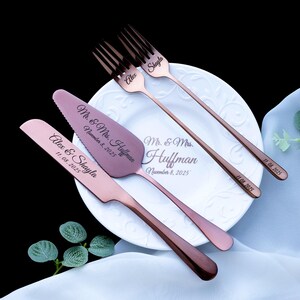 May include: A set of rose gold-toned stainless steel wedding cake serving utensils and two forks. The cake knife and server are engraved with "Alex & Shayla" and "Mr. & Mrs. Huffman November 8, 2025". The forks are engraved with names and dates.