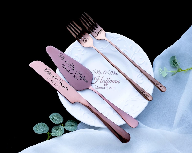 May include: A set of rose gold-toned stainless steel wedding cake serving utensils and two forks. The cake knife and server are engraved with "Alex & Shayla" and "Mr. & Mrs. Huffman November 8, 2025". The forks are engraved with names and dates.