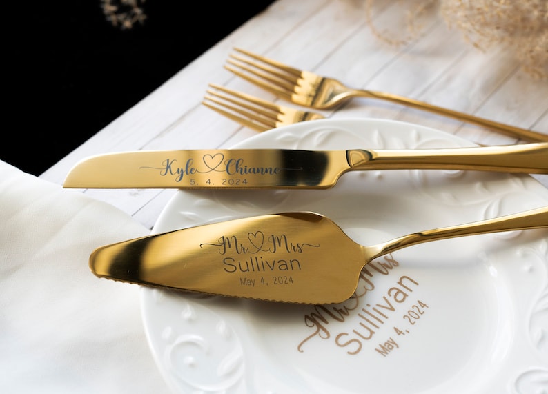 May include: A gold-toned cake knife and server set with custom engraving. The knife features the names Kyle and Chianne with a heart icon and the date 5. 4. 2024. The server is engraved with Mr. & Mrs. Sullivan and May 4, 2024, matching the text on the plate.