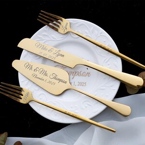 May include: A set of gold-toned stainless steel cutlery including two forks, a knife, and a cake server. The items are engraved with the names Mike and Lynn, the date 11.01.2025, and the text Mr. & Mrs. Thompson, November 1, 2025.