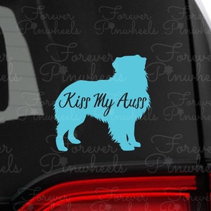May include: A blue silhouette of an Australian Shepherd dog with the text "Kiss My Aus" on a black background.