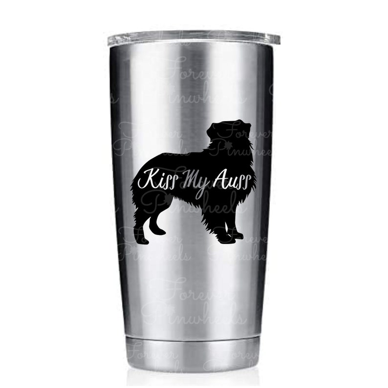 May include: A stainless steel tumbler with a black silhouette of an Australian Shepherd dog and the text "Kiss My Aussy" printed on it.