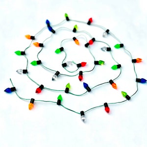 May include: A string of Christmas lights with multi-colored bulbs, including red, green, blue, orange, and clear bulbs.