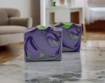May include: Two bars of handmade soap with a swirl pattern in shades of purple and green.