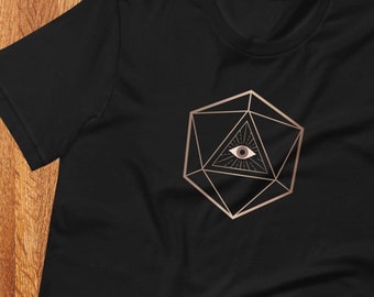 Puede incluir: Camiseta negra con un contorno dorado de un dado de veinte caras con un ojo en su interior. El ojo es marrón con una pupila blanca.