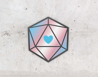 Puede incluir: Un dado de 20 caras diseñado como una bandera de orgullo transgénero rosa, azul y blanca con un corazón azul en el centro.