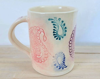 Slab-built Paisley mug with pink, orange, blue, violet and teal paisley stamp decoration, handmade pottery mug