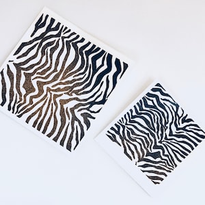 May include: Two black and white zebra print cards. The cards are printed on white paper and have a black and white zebra print design. The print is a gradient of black and white.