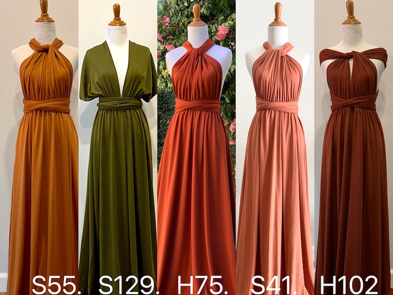 Op de afbeelding: Vijf verschillende gekleurde oneindigheidsjurken op mannequins. De jurken zijn in tinten oranje, groen, rood, roze en bruin. De jurken zijn allemaal gemaakt van een zachte, rekbare stof en kunnen op veel verschillende manieren worden gedragen.  S55. S129. H75. S41. H102.
