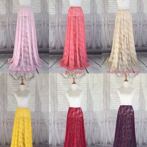 May include: Six different colors of sheer lace maxi skirts. The skirts are displayed on mannequins and are all the same style. The colors are rose quartz, coral, champagne beige, yellow, burgundy, and dark purple.