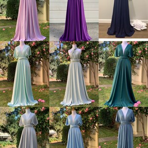 May include: Nine different colors of a convertible wrap dress. The dress is shown on a mannequin in a variety of colors, including lavender, purple, teal, green, light blue, and dark blue. The dress can be worn in multiple ways, making it a versatile option for any occasion.
