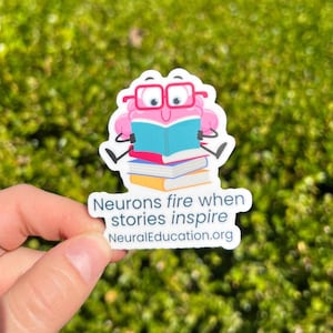 May include: A sticker featuring a pink brain wearing red glasses and reading a blue book atop a stack of books. The sticker has the text "Neurons fire when stories inspire" and "NeuralEducation.org".